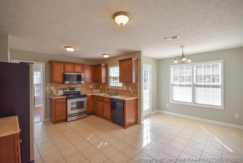 6700 Valley Falls Road Hope Mills, NC 28348 - Photo 11 of 48 a large kitchen with a large counter top stainless steel appliances and cabinets