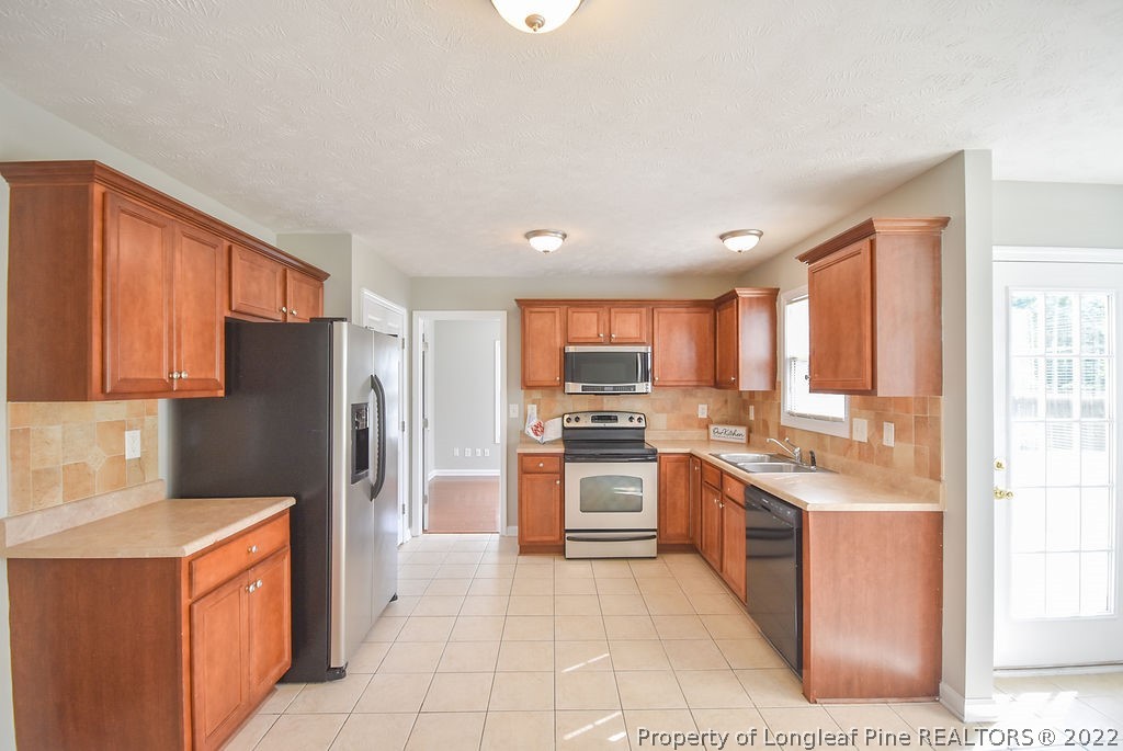 6700 Valley Falls Road Hope Mills, NC 28348 - Photo 12 of 48 a kitchen with stainless steel appliances granite countertop a refrigerator stove and sink