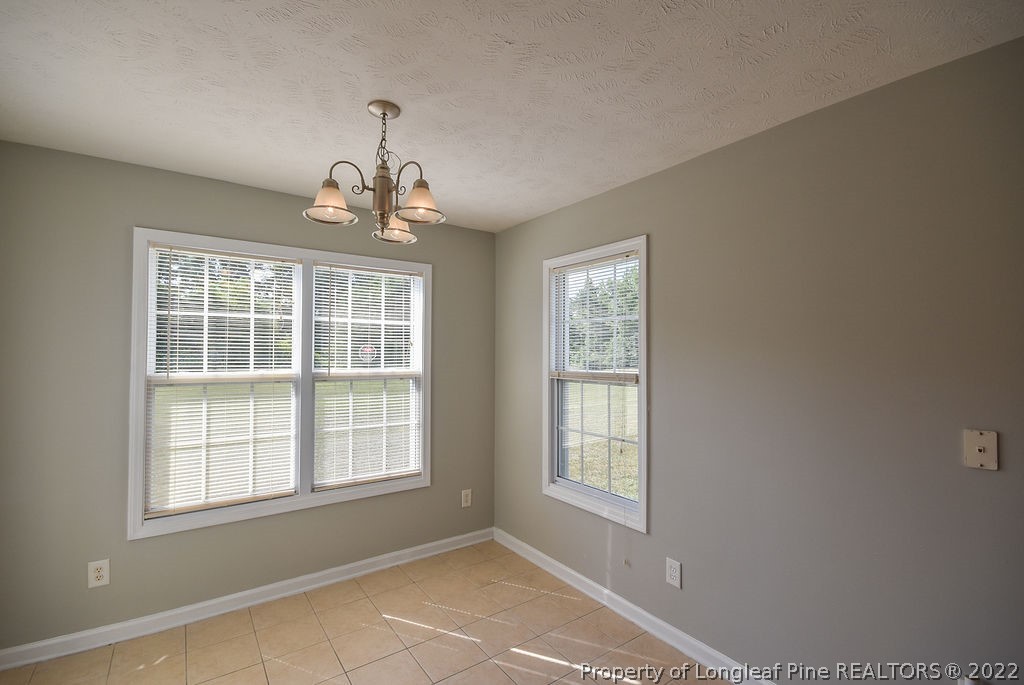 6700 Valley Falls Road Hope Mills, NC 28348 - Photo 17 of 48 an empty room with windows and chandelier