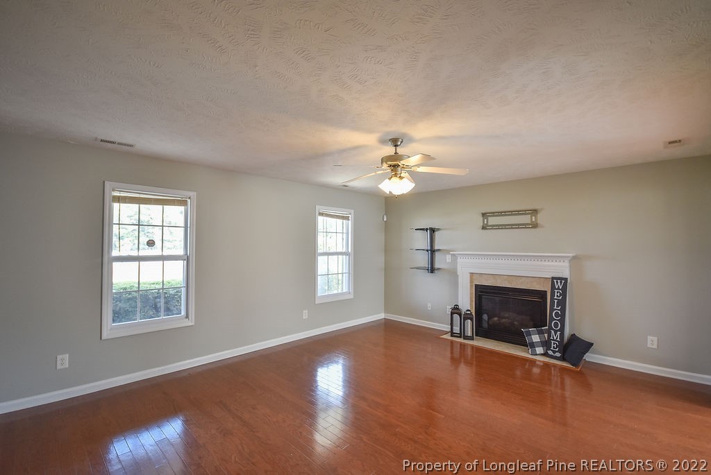 6700 Valley Falls Road Hope Mills, NC 28348 - Photo 10 of 48 an empty room with windows fireplace and wooden floor