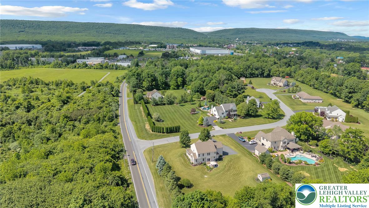204 Bushkill Ridge Road Wind Gap, PA 18091 - Photo 45 of 48 An aerial perspective reveals a serene residential enclave nestled amidst verdant landscapes, showcasing spacious properties with a mountain backdrop.