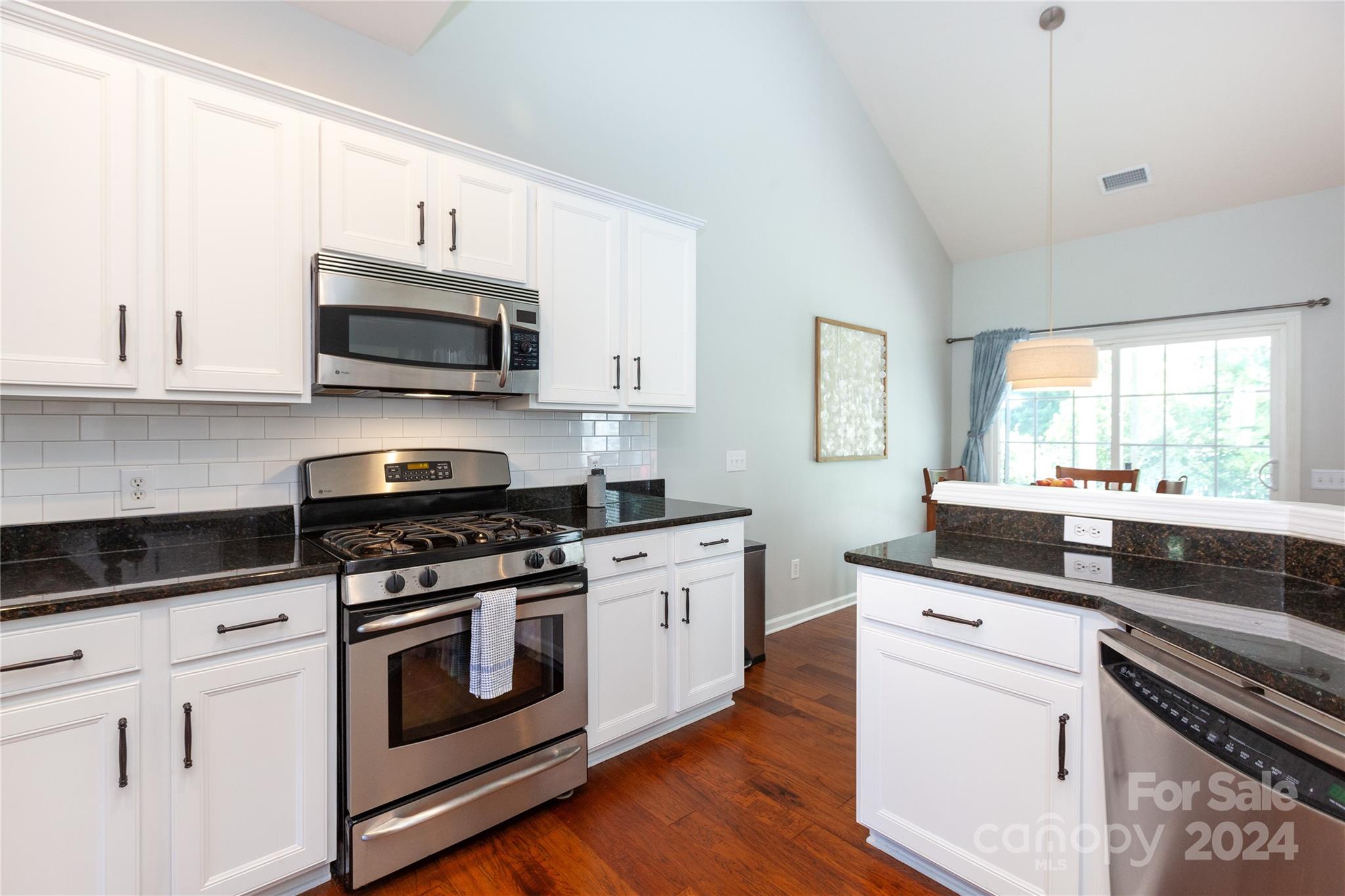 2304 Coltsgate Road Waxhaw, NC 28173 - Photo 13 of 29 a kitchen with granite countertop white cabinets and white appliances