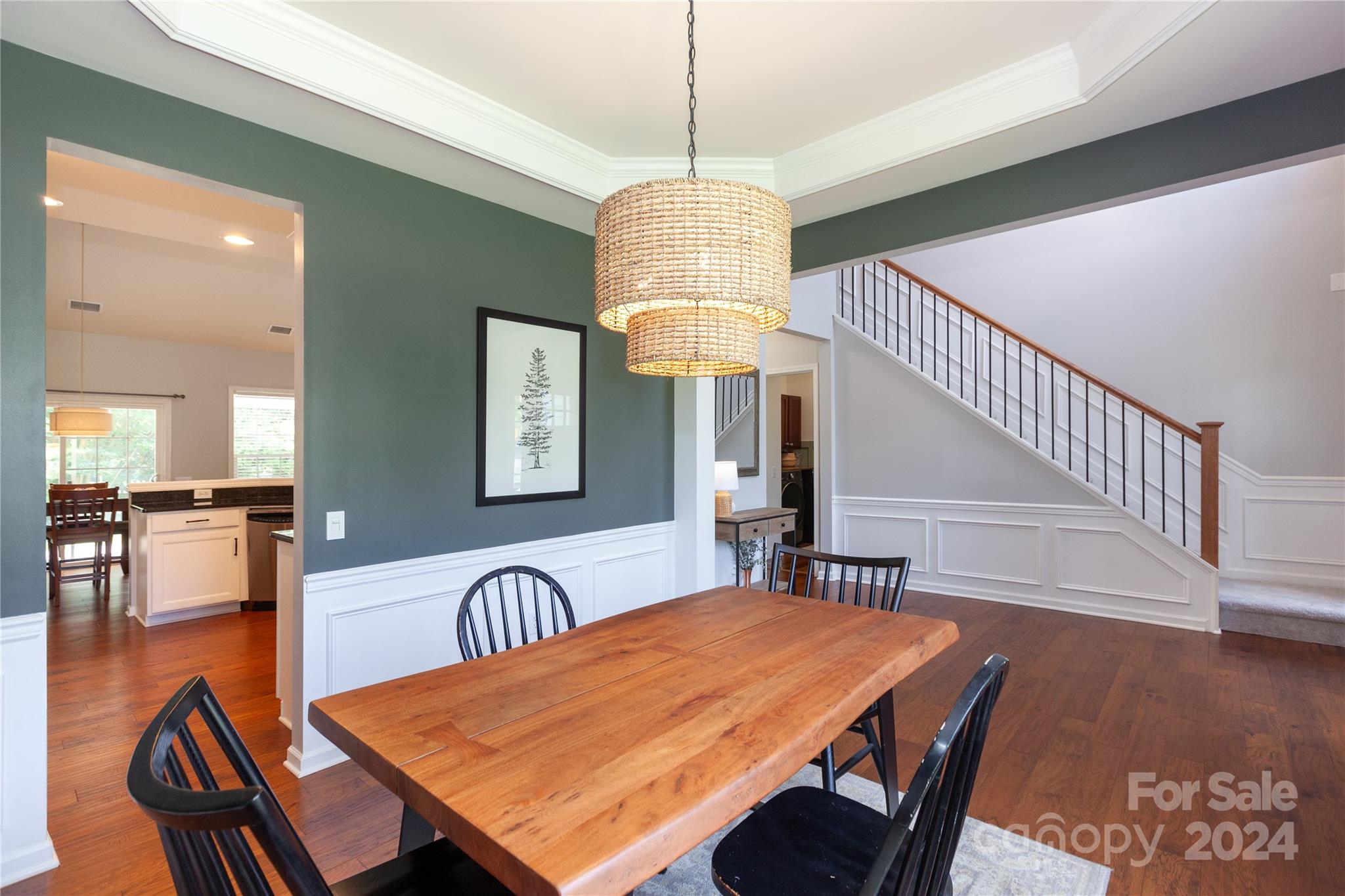 2304 Coltsgate Road Waxhaw, NC 28173 - Photo 4 of 29 a dining room with wooden floor a chandelier a wooden table and chairs