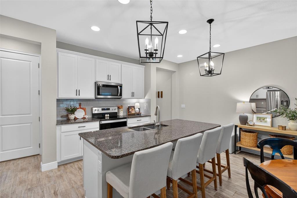 2007 Palm Key Avenue Oldsmar, FL 34677 - Photo 11 of 54 a kitchen with stainless steel appliances granite countertop a dining table chairs refrigerator and microwave