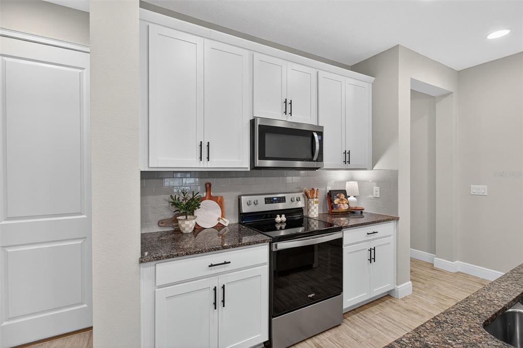2007 Palm Key Avenue Oldsmar, FL 34677 - Photo 10 of 54 a kitchen with stainless steel appliances granite countertop white cabinets sink and stove