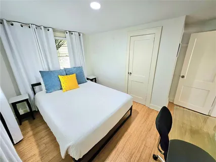 a bedroom with a bed and wooden floor