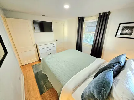 a bedroom with a bed tv and a mirror