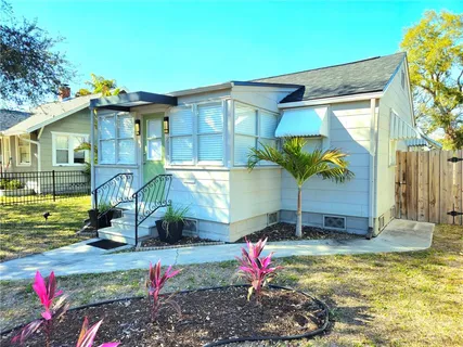 a view of a backyard with table and chairs potted plants