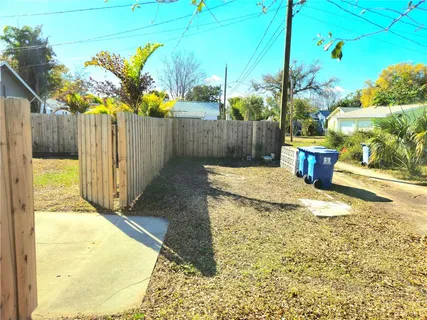a view of a house with a yard and a large tree