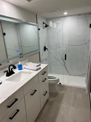 a bathroom with a double vanity sink a toilet and a mirror