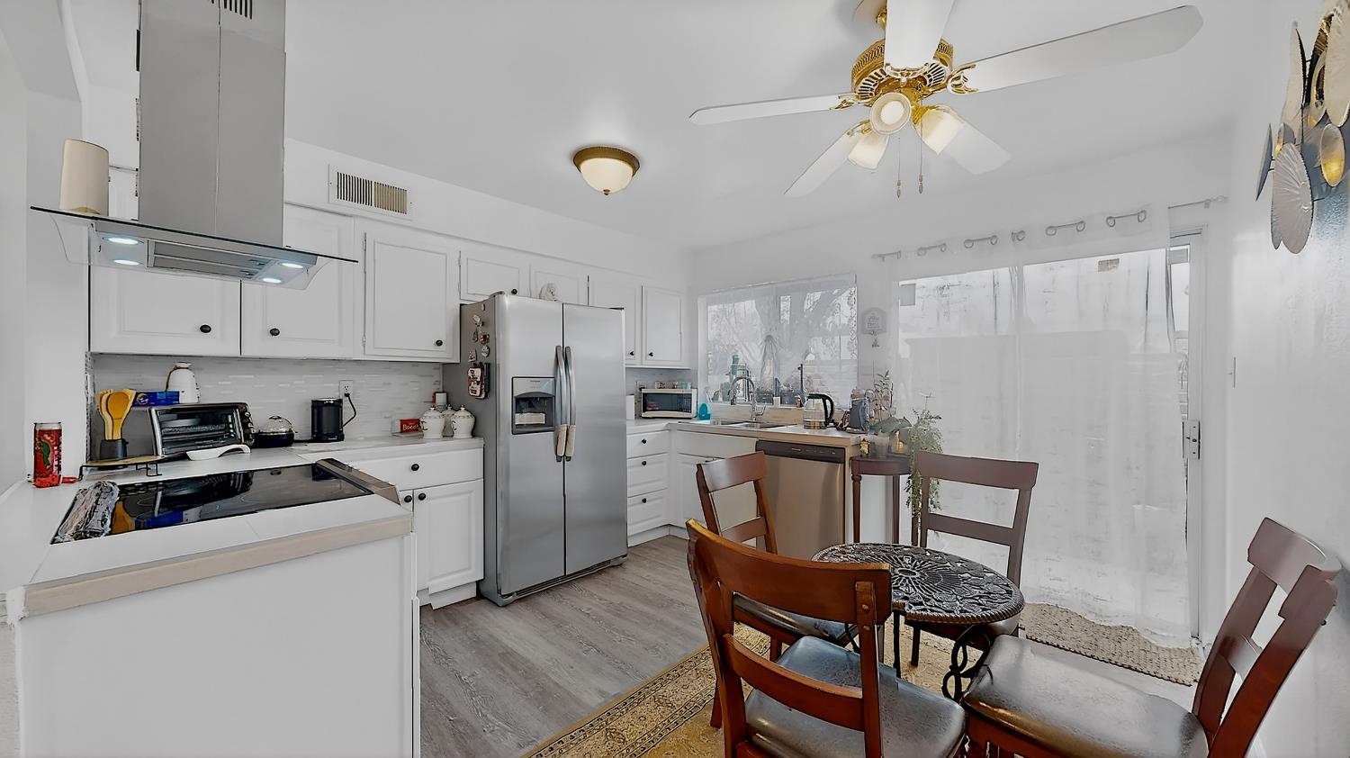617 West Granger Avenue, Unit 66 Modesto, CA 95350 - Photo 11 of 46 a kitchen with refrigerator a stove a sink dishwasher a dining table and chairs with wooden floor
