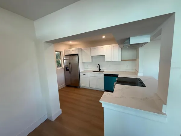 a kitchen with a refrigerator a sink and cabinets