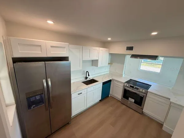 a kitchen with a refrigerator and a sink