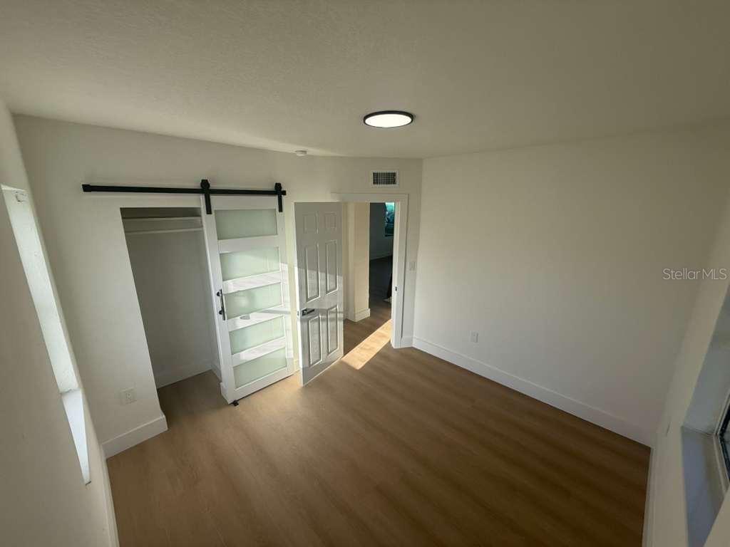 18015 2nd Street East Redington Shores, FL 33708 - Photo 6 of 10 an empty room with wooden floor