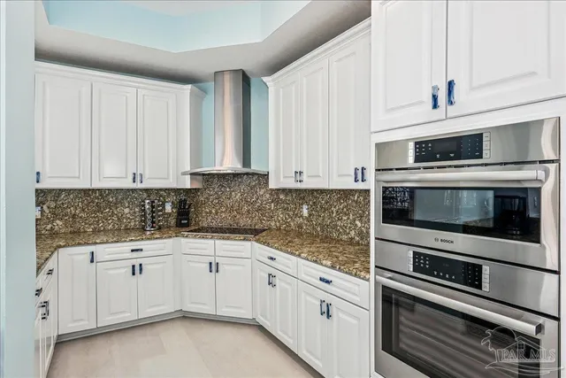 a kitchen with white cabinets and sink