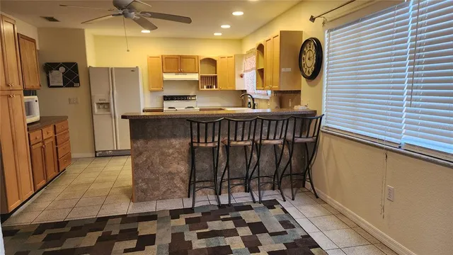 a kitchen with a sink a refrigerator and cabinets
