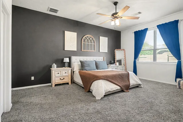 a spacious bedroom with a bed and a window