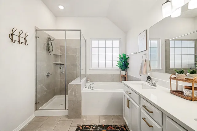 a bathroom with a tub sink shower and mirror