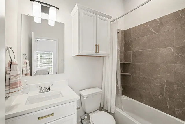 a bathroom with a sink toilet a mirror and shower