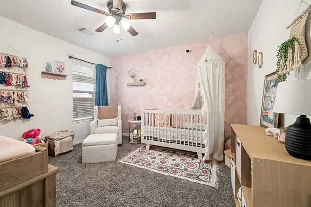 a living room with furniture and a baby crib