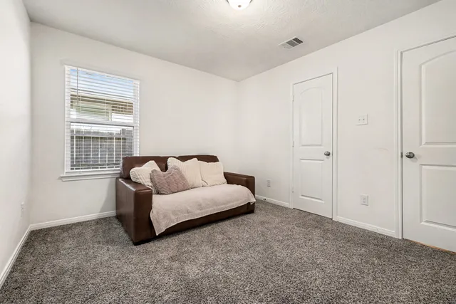 a spacious bedroom with a bed and a window