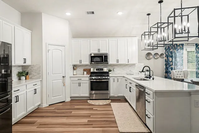 a kitchen with stainless steel appliances granite countertop a stove and a sink