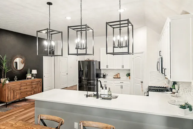a kitchen with kitchen island white cabinets and refrigerator
