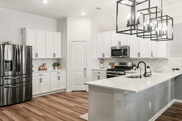 a kitchen with kitchen island a sink stainless steel appliances and window