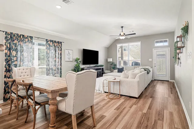 a living room with furniture a flat screen tv and large windows