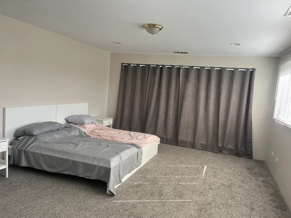 a bedroom with a bed and a curtain