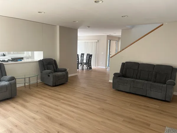 a living room with furniture and a wooden floor
