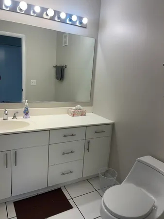 a bathroom with a toilet sink and mirror