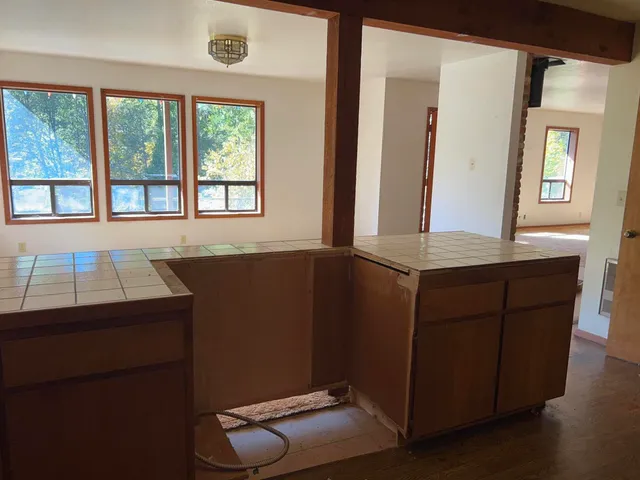 a walk in closet with wooden floor