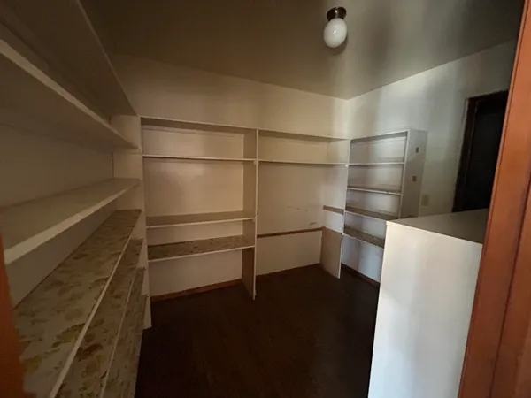 a view of a hallway with wooden floor and a living room