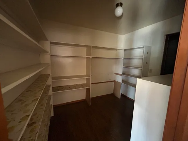 a view of a hallway with wooden floor and a living room