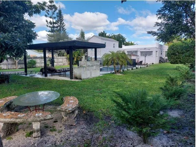 a view of a house with backyard and sitting area