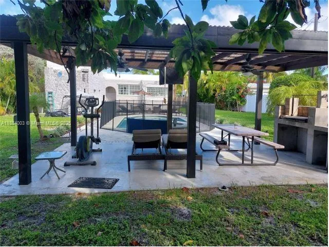 a view of a patio with table and chairs potted plants and palm tree
