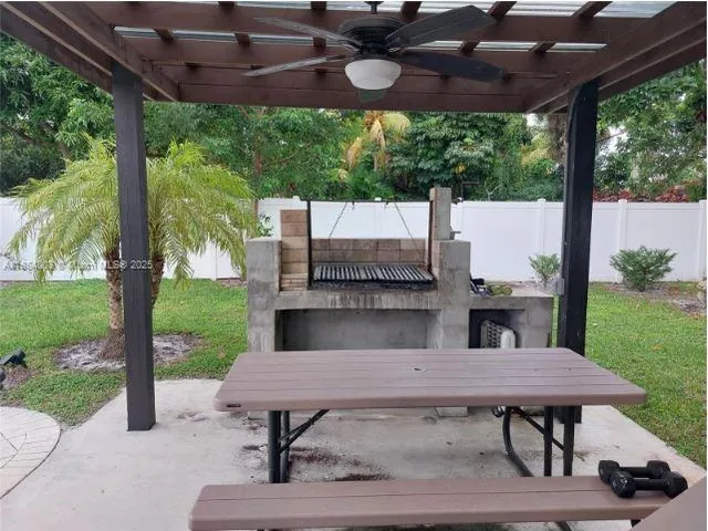 a view of a patio with table and chairs potted plants with wooden floor and fence