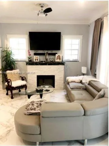 a living room with furniture a fireplace and a flat screen tv