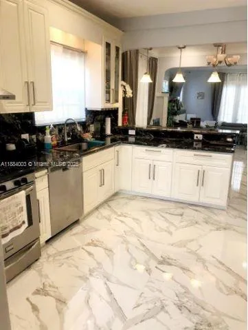 a kitchen with stainless steel appliances kitchen island granite countertop a sink and cabinets
