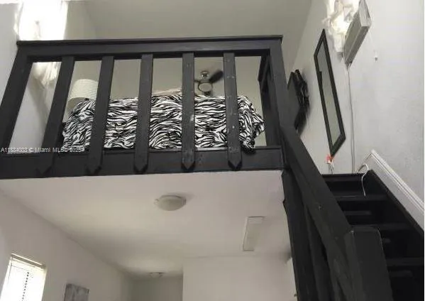 a bedroom with a bed and a flat tv screen on a dresser