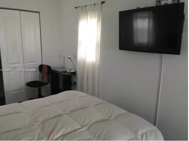 a bed sitting in a bedroom next to a window