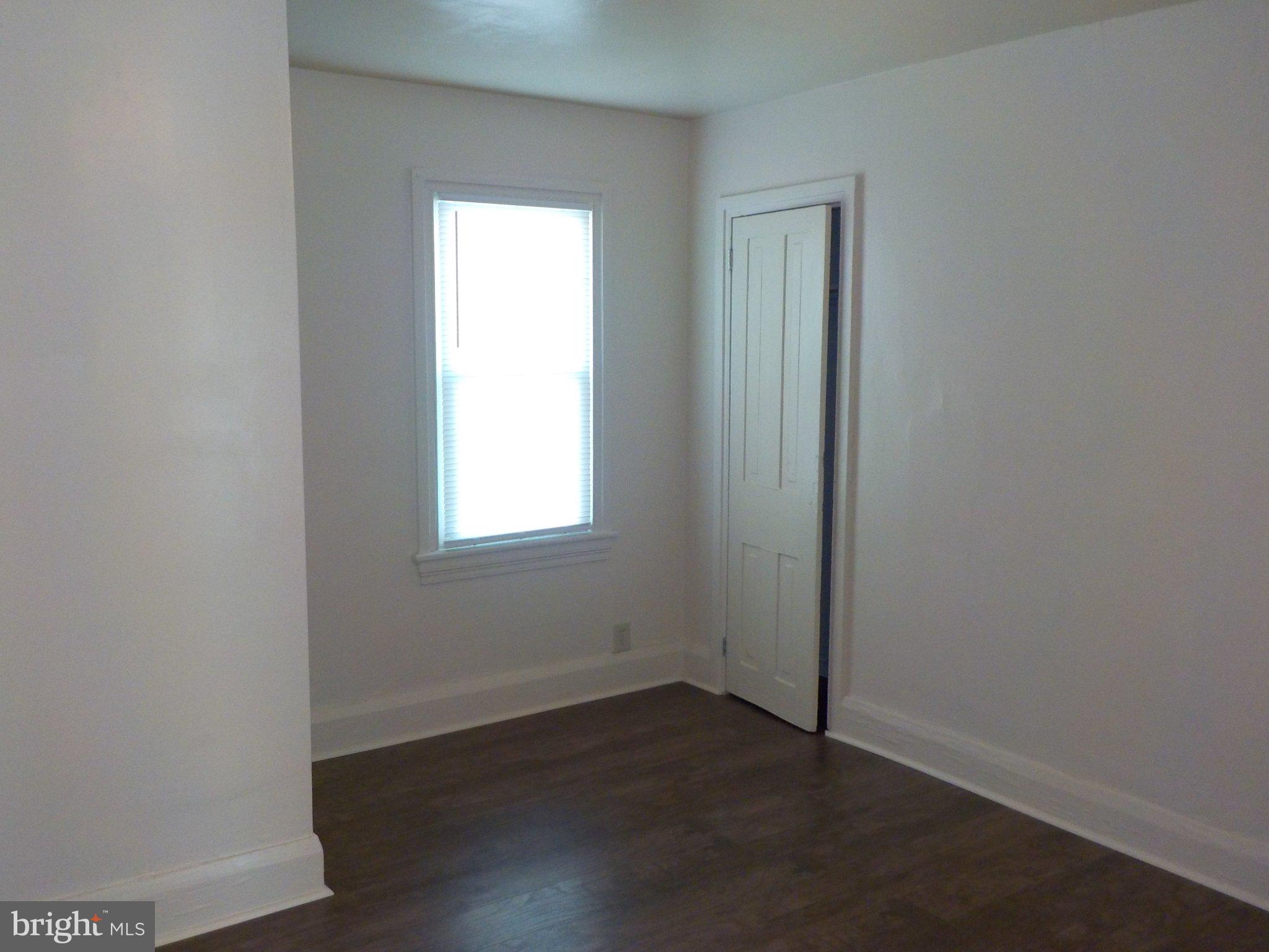 26 Walnut Street, Unit A Salem, NJ 08079 - Photo 6 of 11 an empty room with wooden floor and windows