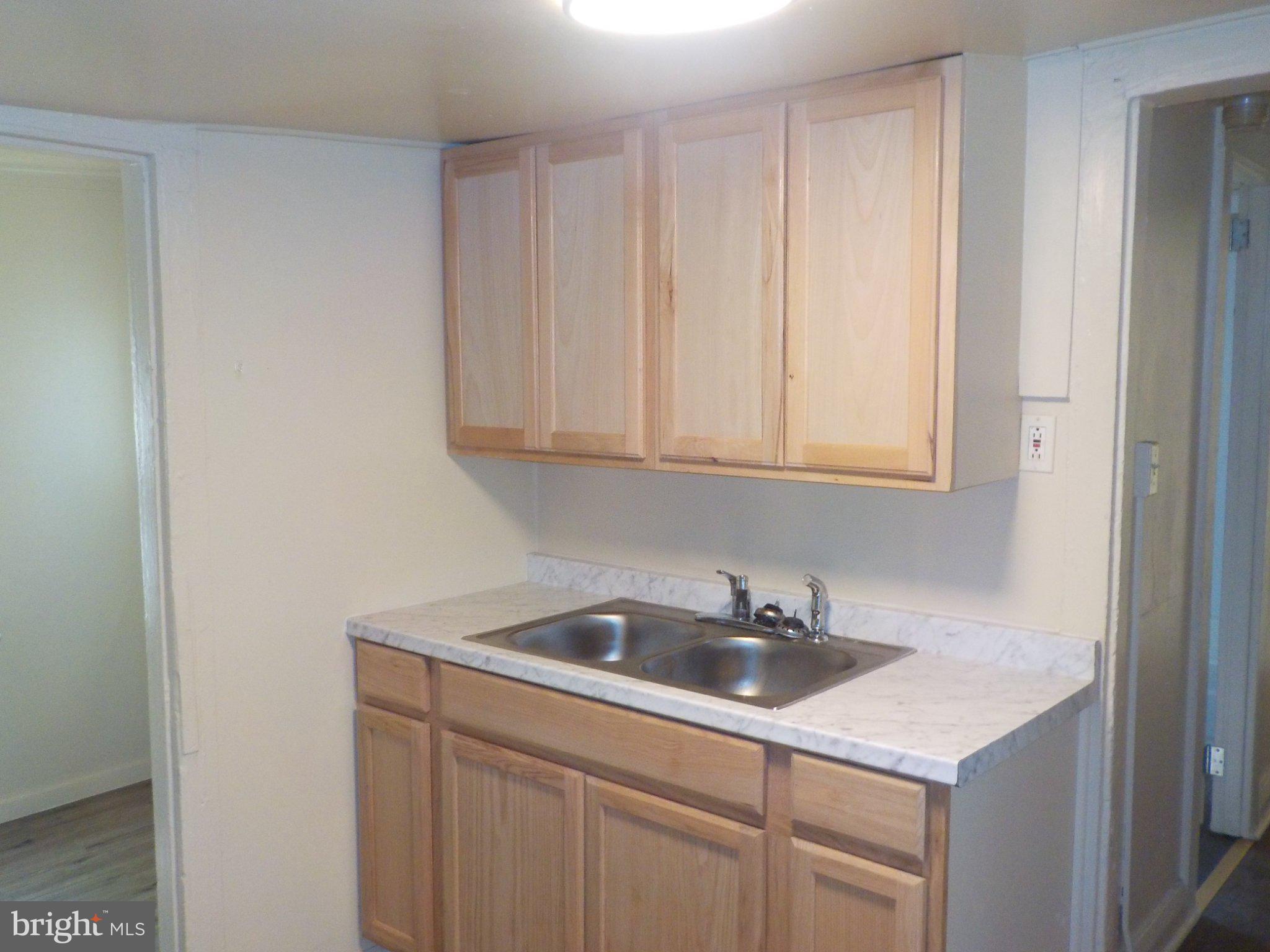 26 Walnut Street, Unit A Salem, NJ 08079 - Photo 10 of 11 a kitchen with white cabinets a sink and dishwasher