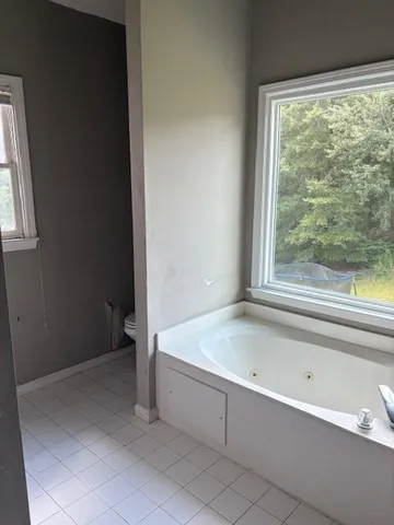a spacious bathroom with a bathtub and shower