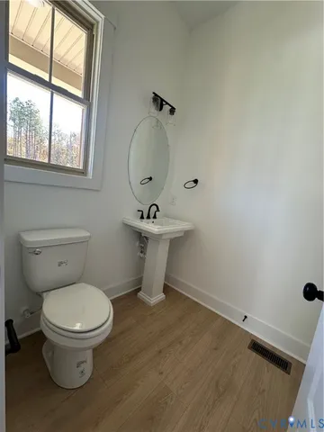 an empty room with wooden floor and entrance