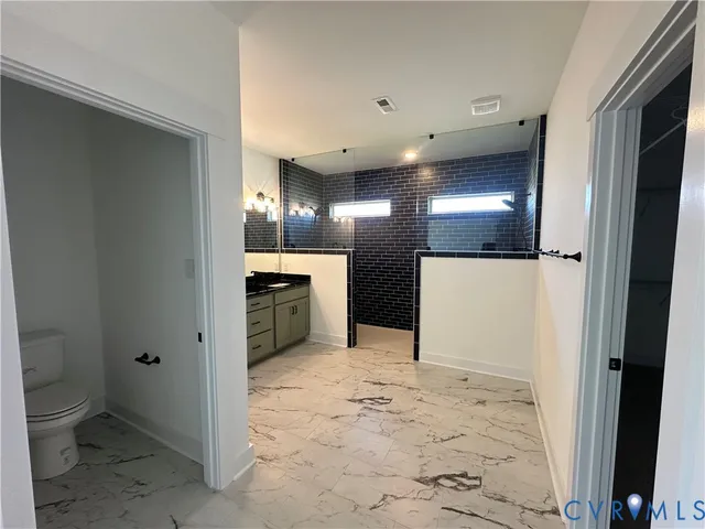 a bathroom with a granite countertop sink and a black and white cabinet