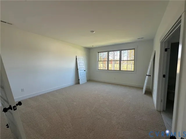 a view of a hallway to a kitchen with a sink and a toilet