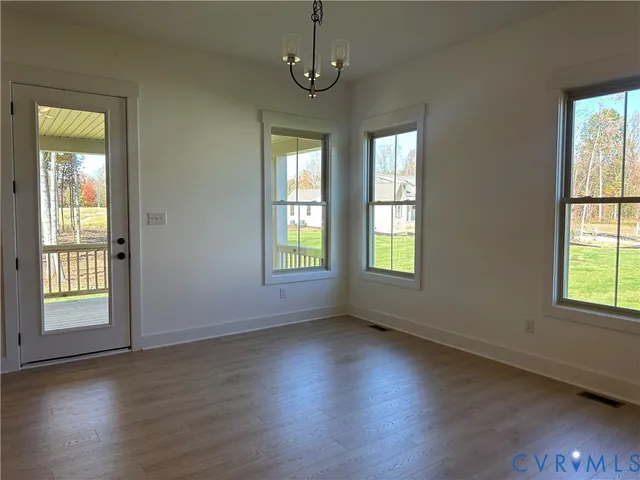 an empty room with wooden floor and a ceiling fan