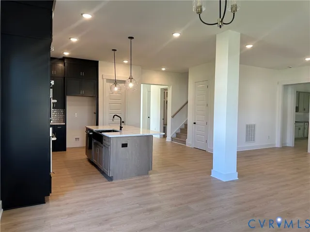 a large room with kitchen view and wooden floor